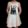 A white slip dress featuring a screen printed design of doberman dogs, with adjustable straps.