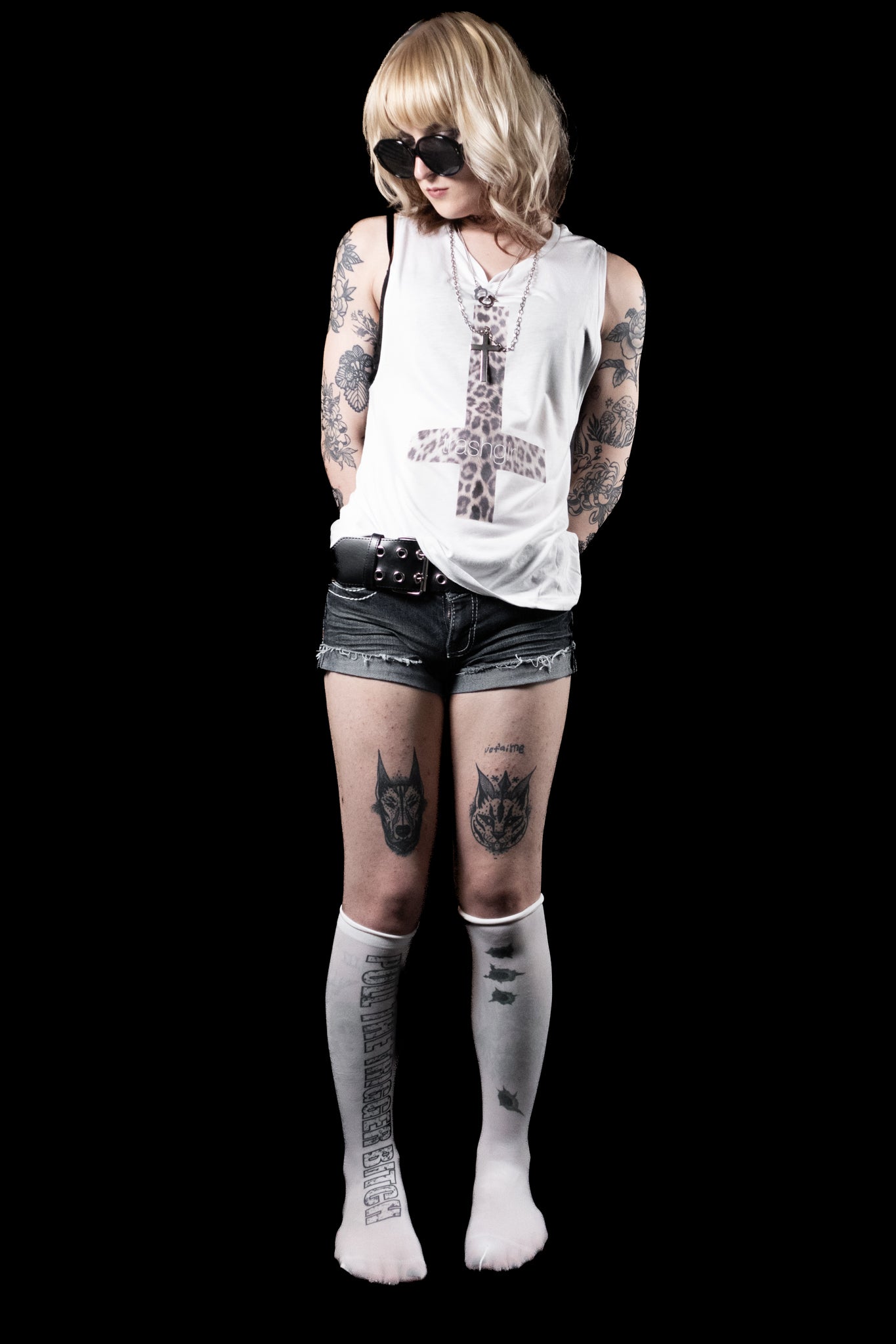 Person wearing a white sleeveless top, black shorts, and white socks with text on a black background