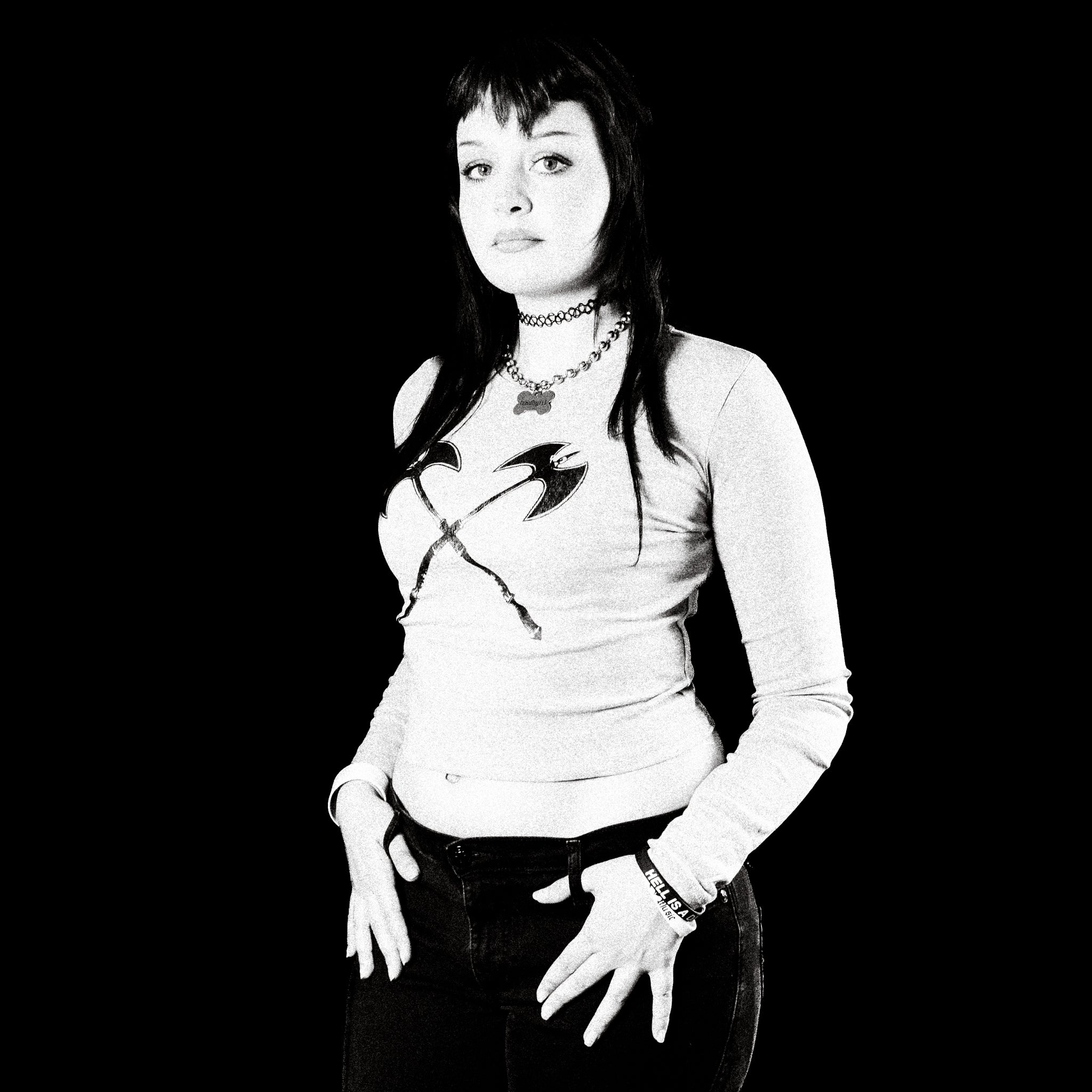 Black and white portrait of a woman with a choker and necklace against a black background