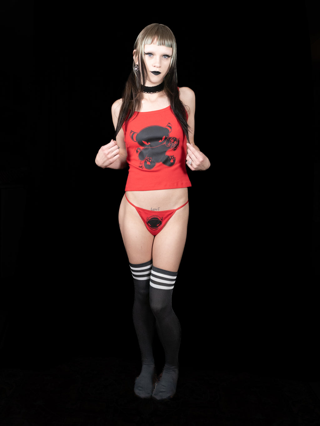 Person wearing a red outfit with black designs on a black background